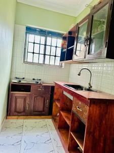 a kitchen with wooden cabinets and a sink at Kisubi Forest View in Entebbe