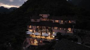 ein großes Gebäude mit Lichtern vor einem Berg in der Unterkunft Ha Giang Aya Lodge by Localvietnam in Dồng Văn