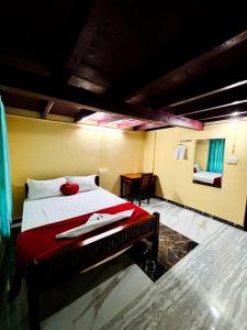 1 dormitorio con 1 cama con manta roja y mesa en Edwin and Edrin Service Villa, en Wayanad