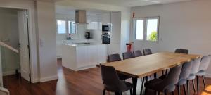 a kitchen and dining room with a wooden table and chairs at Villa Lina in Lourinhã