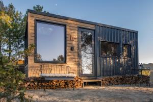 a tiny house with a large window and a bench at Cabañas en el bosque cerca de Barcelona in Talamanca