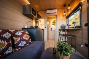 a living room with a couch in a tiny house at Cabañas en el bosque cerca de Barcelona in Talamanca