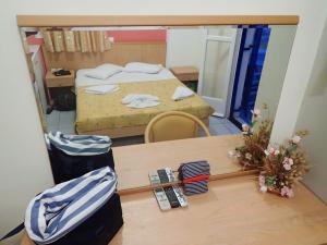 a room with a bed and a table with a mirror at Villa Markos in Perissa