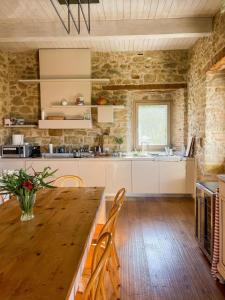 a kitchen with a wooden table and chairs in a room at Palazzo Serre - Natura & Piscina in San Leo