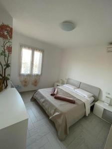 a bedroom with a bed in a white room at Amicizia in Valledoria