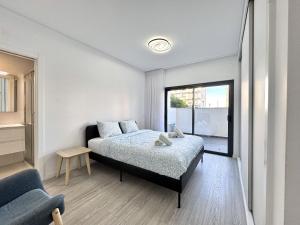 Faro Prestige by Homing في فارو: غرفة نوم بها سرير ونافذة كبيرة