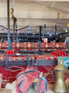 a room filled with lots of red chairs and books at Whispering Rum in Wadi Rum