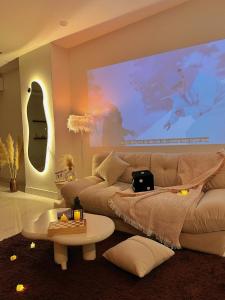 a living room with a couch and a large screen at Huế Nestory Homestay in Thôn Trường Giang