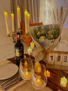 a table with glasses and candles and a bottle of wine at Huế Nestory Homestay in Thôn Trường Giang