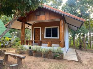 a small house with a bench in front of it at เฮินไตเกสเฮาส์ in Ban Nong Pa Ko +8 photos