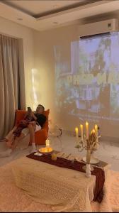 a man sitting on a couch in front of a screen at Huế Nestory Homestay in Thôn Trường Giang