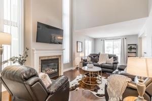 een woonkamer met banken en een open haard bij Alpine Hideaway - Walk to Blue Mountain in Blue Mountains