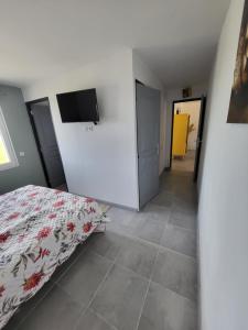 a bedroom with a bed and a flat screen tv at La maison de la Motte in La Motte-Fanjas