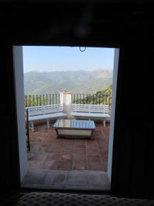 a view of a patio with a couch and benches at Casas Rurales Jardines del Visir in Genalguacil