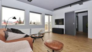 una sala de estar con un sofá y una mesa en LL Properties - TB24 Elegant Escape w Hot-tub Access, en Akureyri