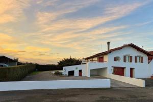 a white house with a sunset in the background at Loustaou in Bidache
