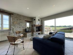 a living room with a blue couch and a stone wall at Loustaou in Bidache