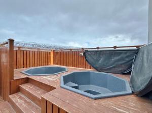 una terraza con dos jacuzzis en un balcón en LL Properties - TB24 Elegant Escape w Hot-tub Access, en Akureyri 19 fotos más