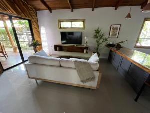 a living room with a white couch and a tv at Casa Adam in Pochote