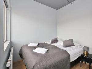 un dormitorio con una cama con dos almohadas. en LL Properties - TB24 Elegant Escape w Hot-tub Access, en Akureyri