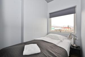 Un dormitorio con una cama con ventana. en LL Properties - TB24 Elegant Escape w Hot-tub Access, en Akureyri