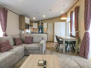 een woonkamer met een bank en een tafel bij Blue Skies in Llanwnda