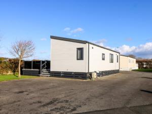 een groot wit gebouw op een parkeerplaats bij Blue Skies in Llanwnda