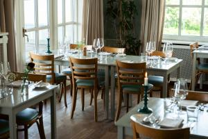 a dining room with tables and chairs with wine glasses at Helenekilde Badehotel in Tisvildeleje