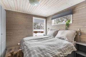 Un dormitorio con una cama en una habitación con paredes de madera. en Modern Cabin Near Maldalsvatnet And Reinsnuten, en Saudasjøen