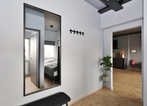 espejo en la pared de un dormitorio con cama en LL Properties - TB24 Elegant Escape w Hot-tub Access, en Akureyri