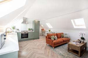 a living room with a couch and a kitchen at Barney's Barn in Woodbridge