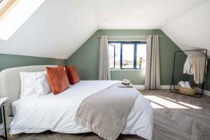 a bedroom with a bed with orange pillows and a window at Barney's Barn in Woodbridge