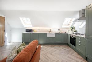 a kitchen with green cabinets and a couch at Barney's Barn in Woodbridge +16 photos