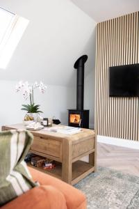 a living room with a fireplace and a wooden coffee table at Barney's Barn in Woodbridge