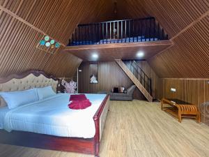 a bedroom with a large bed with a wooden ceiling at Wings Cottage in Ooty