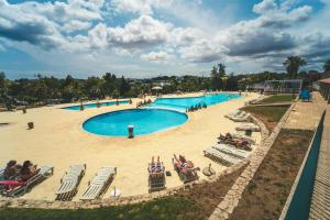 阿尔布费拉HolaCamp Albufeira的大型游泳池,人们坐在草坪椅上