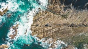an aerial view of the ocean and cliffs at HolaCamp Albufeira in Albufeira