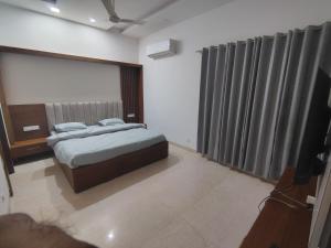 ein Schlafzimmer mit einem Bett und einem Fernseher darin in der Unterkunft Casa Morals 3BHK in Chandigarh Airport