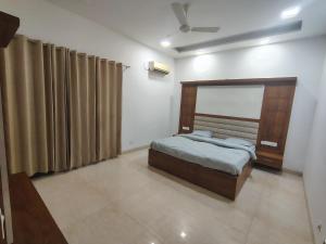 ein Schlafzimmer mit Bett und Vorhängen in einem Zimmer in der Unterkunft Casa Morals 3BHK in Chandigarh Airport