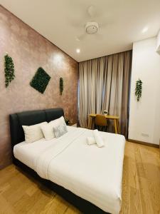 吉隆坡Lucentia Residence Skyline KL Stay的一间卧室，里面有一张铺着白色床单的大床。