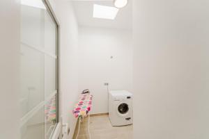 a laundry room with a washing machine and a chair at Apartment Old Town Reina Sofia 1 in Puerto del Carmen