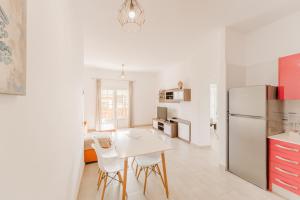 a kitchen with a white table and a white refrigerator at Apartment Old Town Reina Sofia 1 in Puerto del Carmen +3 photos