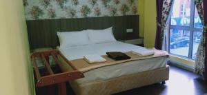 a bedroom with a bed with two towels on it at Casa D'rose Hotel in Malacca
