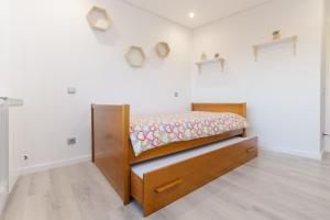 a bedroom with a bed in a white wall at Apartamento do Sol, Lobão 