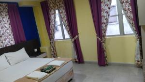 a bedroom with a bed and two windows at Casa D'rose Hotel in Malacca +1 photo