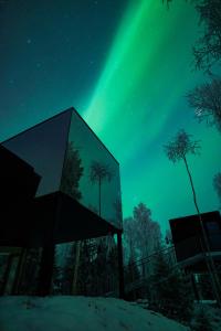 Un cielo verde con la aurora boreal en el cielo. en Silver Birch Resort Lapland, en Rovaniemi
