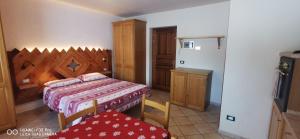 a bedroom with a bed and a table and chairs at Monolocale Belvedere in La Thuile
