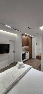una camera bianca con un grande letto e una cucina di STAY-FIVE Cozy Modern Studios in Tirana Center - Brand New a Tirana