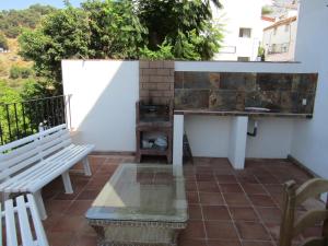 a balcony with a bench and a table and a counter at Casas Rurales Jardines del Visir in Genalguacil