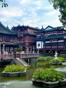 Un edificio con un puente y flores en el agua. en Downtown, 2BR 1LR 1KT 1BA, near Pedestrian St, the Bund, Pearl Tower, en Shanghái